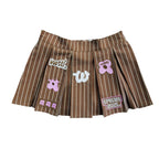 WUUSKÎ "Unîversity" pleated mini skort — attached satin shorts, embroidery patches