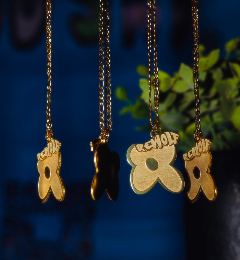 "Rewolf" gold necklace by WUUSKÎ — close detail, 14k gold figaro chain and charms